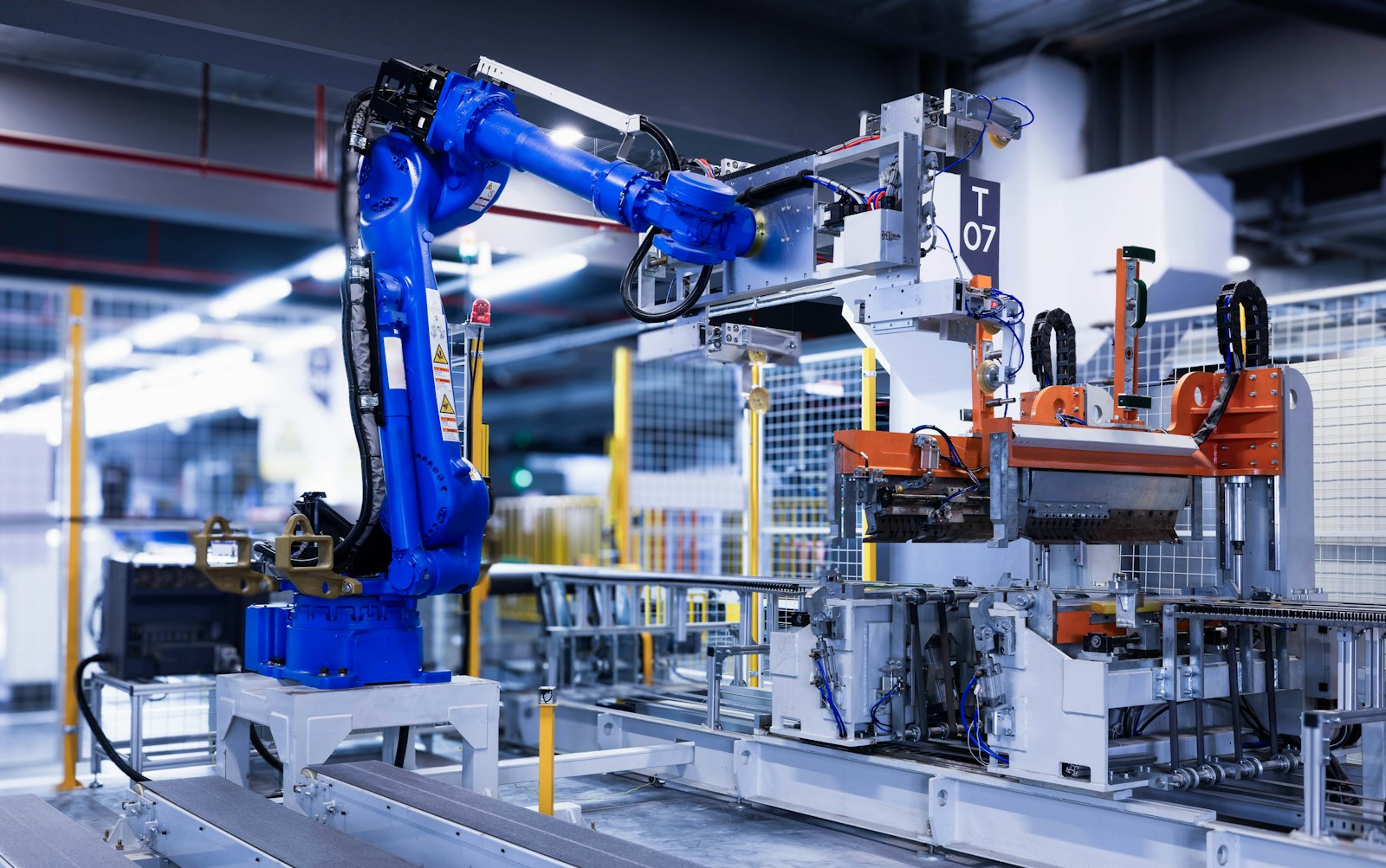 A blue industrial robot arm working on a factory line